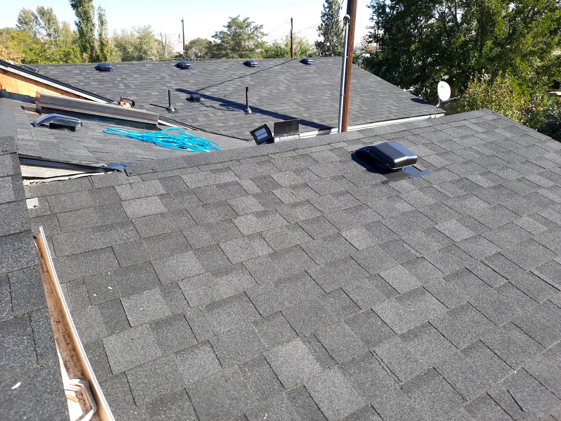 Completed dark architectural shingle roof with ridge vents and clean lines